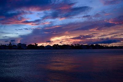 Scenic view of sea against cloudy sky during sunset