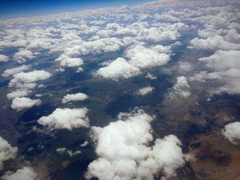 High angle view of airplane flying over landscape against sky