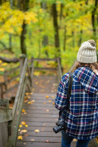 Rear view of woman hiking on trail in autumn in porcupine mountains state park, michigan