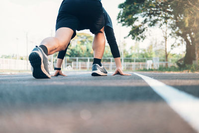 Rear view of man in race start position on road