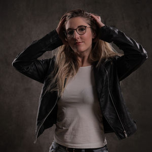 Portrait of young woman standing against wall