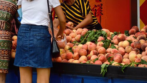 People buying peaches at market