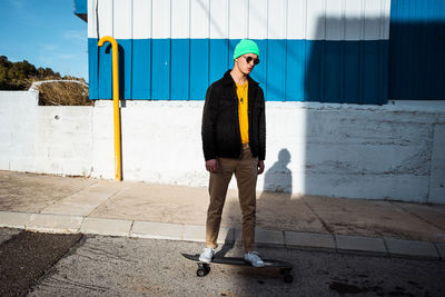 Full length of young man standing against wall