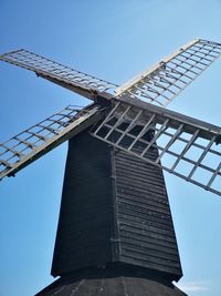 Low angle view of traditional windmill against clear blue sky