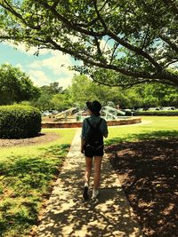 Full length rear view of woman walking on grass