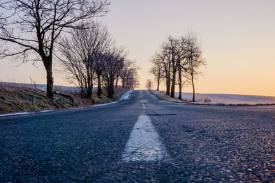 Empty road along trees