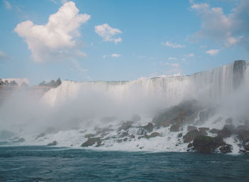 Scenic view of waterfall against sky