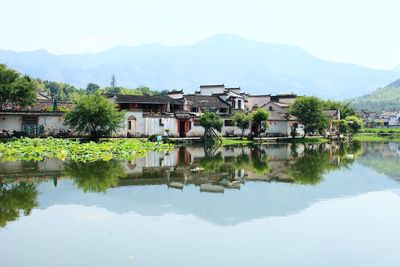 Reflection of buildings on lake against sky