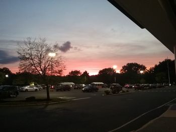 Cars on road against sky during sunset