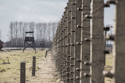 Wooden posts on field against sky