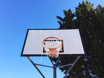 Low angle view of basketball hoop against clear blue sky