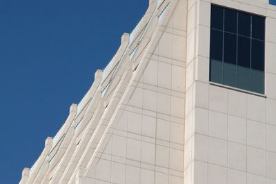 Low angle view of modern building against clear blue sky