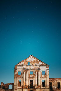 Low angle view of old building against blue sky