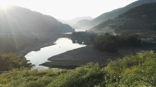 Scenic view of lake and mountains against sky