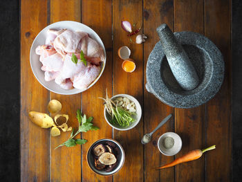 Directly above shot of ingredients with meat and mortar on wooden table