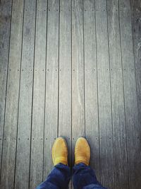 Low section of man standing on wooden floor