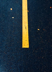 High angle view of yellow arrow sign on road