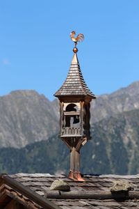 Close-up of cross against clear blue sky