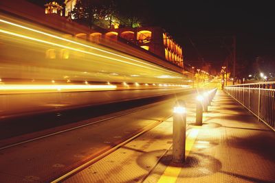Blurred motion of illuminated cable car on street in city at night