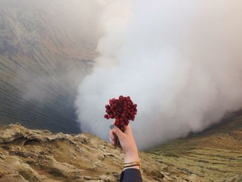 Low angle view of woman hand against mountain