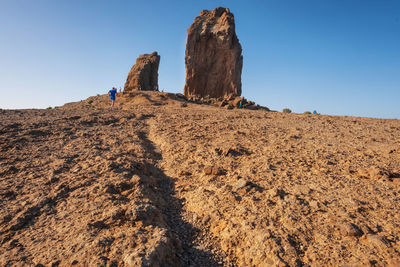 Low angle view of rock formations against clear blue sky