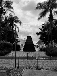 Street light and palm trees in park against sky