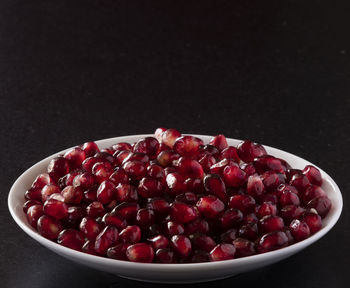 Close-up of strawberries in bowl against black background