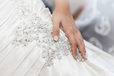 Midsection of bride wearing white wedding dress