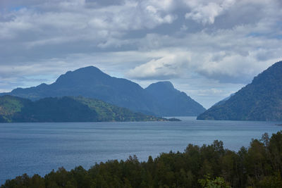 Scenic view of sea and mountains against sky