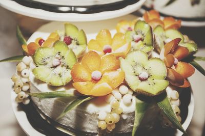 Close-up of wedding cake decorated with fruits on table