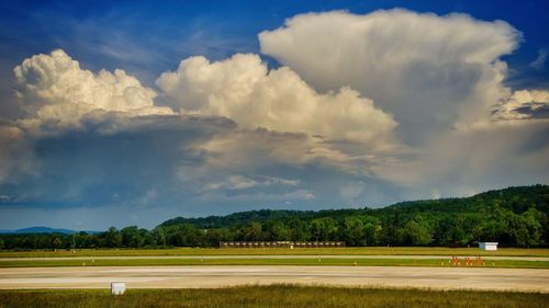 Scenic view of grassy field against cloudy sky