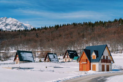 House on snow covered mountain against sky