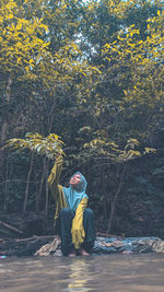 Young woman looking at camera while sitting on land