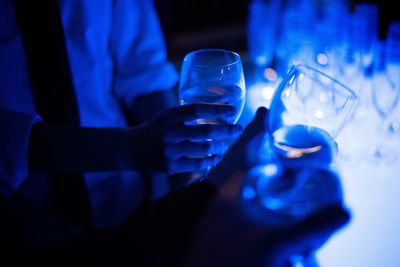 Close-up of hand holding drink on table