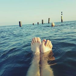 Low section of woman relaxing in sea