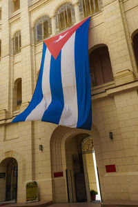 Low angle view of flag against buildings in city