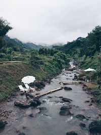 Scenic view of river by mountains against sky