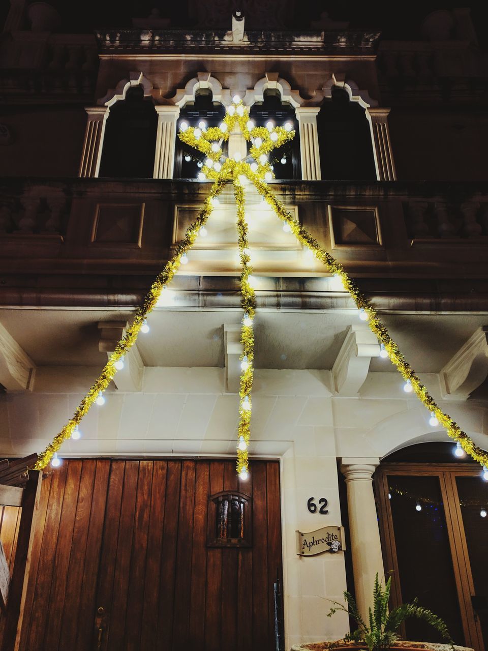 LOW ANGLE VIEW OF ILLUMINATED LIGHTS HANGING IN BUILDING