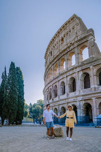 Couple by historical building against sky