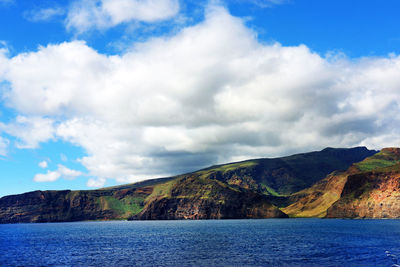 Scenic shot of calm sea with mountain range in background