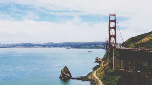 View of bridge over sea against cloudy sky