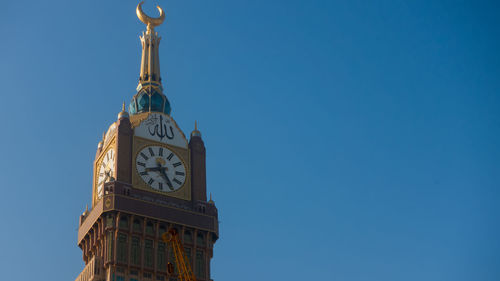 Low angle view of clock tower against blue sky