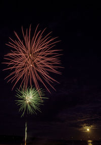 Low angle view of firework display at night