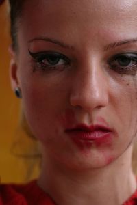 Close-up portrait of sad woman with messy make-up