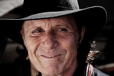 Close-up of smiling man wearing hat looking away outdoors