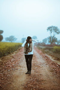 Woman standing on road against sky