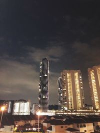 Low angle view of illuminated buildings against sky at night