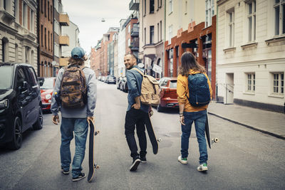 Smiling man walking with male friends in city