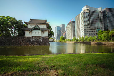 Lake by buildings against sky in city