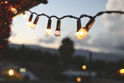Low angle view of illuminated light bulb against sky at night